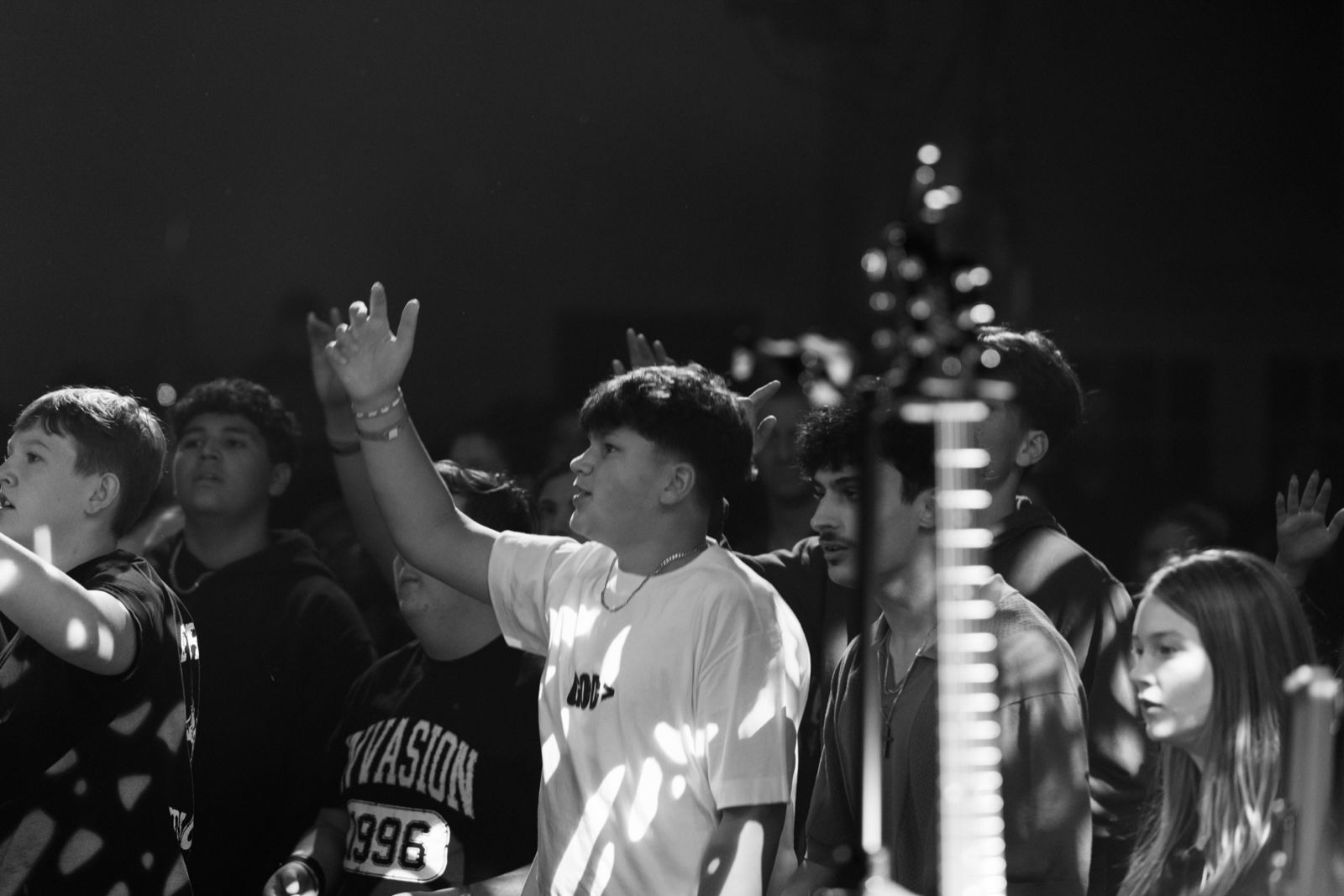 A student worshipping in an Invasion 1996 shirt
