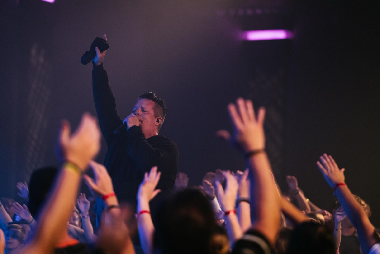 Hands raised as the band leads