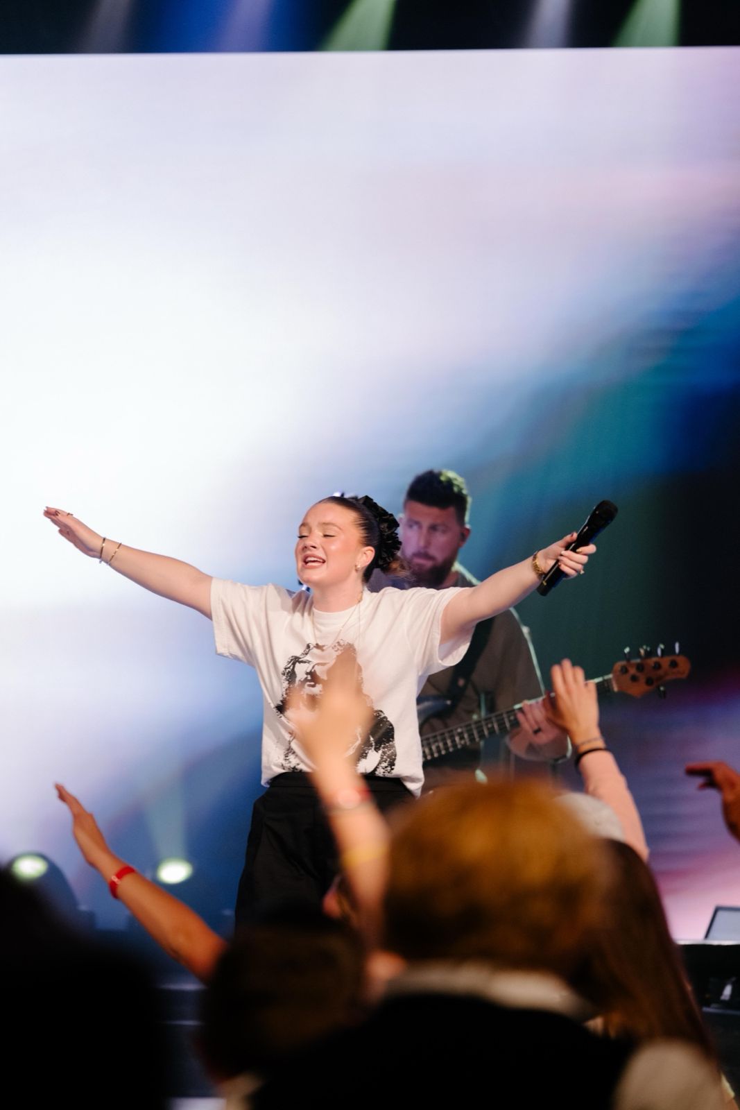 A student with arms wide open in worship